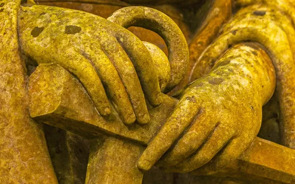 A statue's hands are the focus of an image.