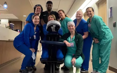 A group of medical workers standing around a massage chair.