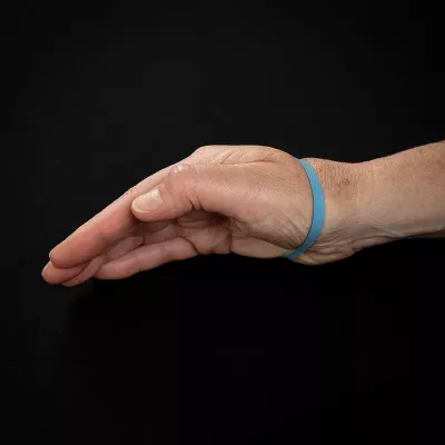 Demonstration of exercise for the thumb with rubber band around the hand and fingers.