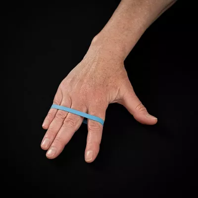 Step 2 of the exercise from Image 15 with the index finger extended and rubber band around the fingers.