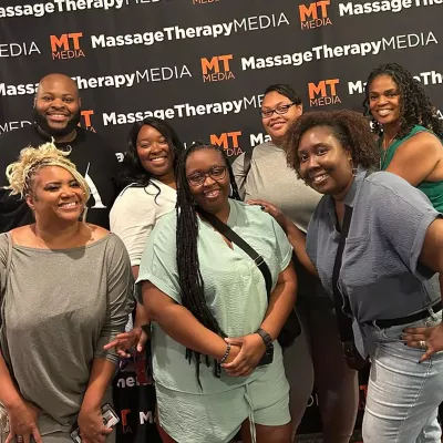 Seven attendees at the inaugural Black Massage Therapist Conference smile for a photo.