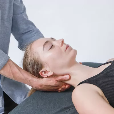 A massage therapist decompresses a client's neck.