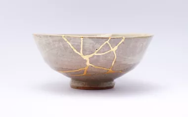 Conceptual, ceramic bowl with light showing through cracks.