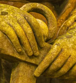 A statue's hands are the focus of an image.