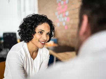 A woman and a man have a discussion in a professional mentor relationship.