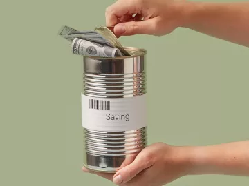 Two hands holding and opening a silver can with a dollar inside.