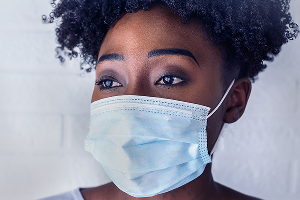 A woman wearing a blue surgical mask 
