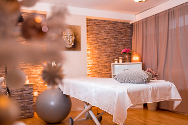 Tranquil and inviting spa setting with soft lighting and a massage table 