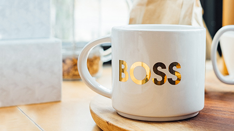 A coffee mug with the word â€œBOSSâ€ emblazoned in gold lettering.