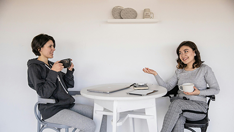 Two people sitting at a table drinking coffee.