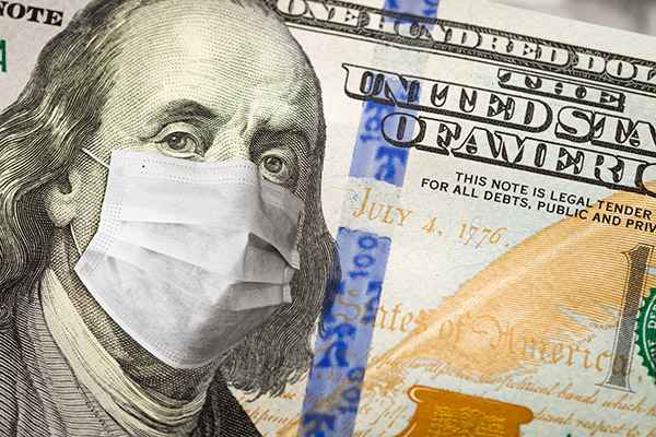 One hundred dollar bill with a surgical mask over Benjamin Franklin's face