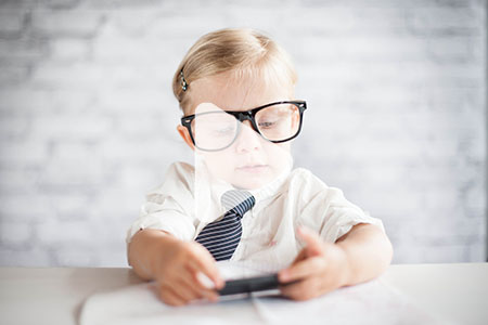 A child in glasses looking at an open accounting book