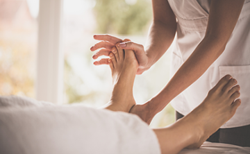 Therapist performing foot massage.