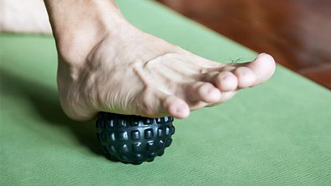 Image of a foot rolling over a exercise ball.