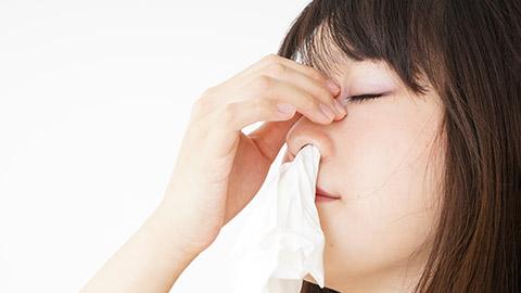Image of a person with tissue in their nose trying to stop a nose bleed.