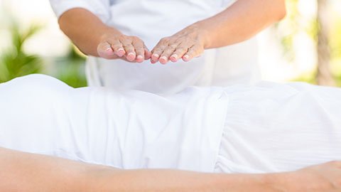 Reiki treatment performed with hands hovering over client's abdomen